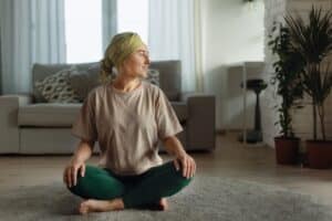 Young woman with cancer on floor doing yoga