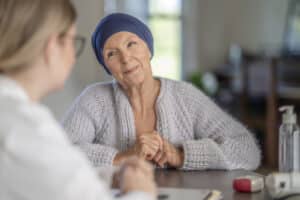 Woman in a headscarf discussing breast cancer surgery and mastectomy options with a healthcare provider.